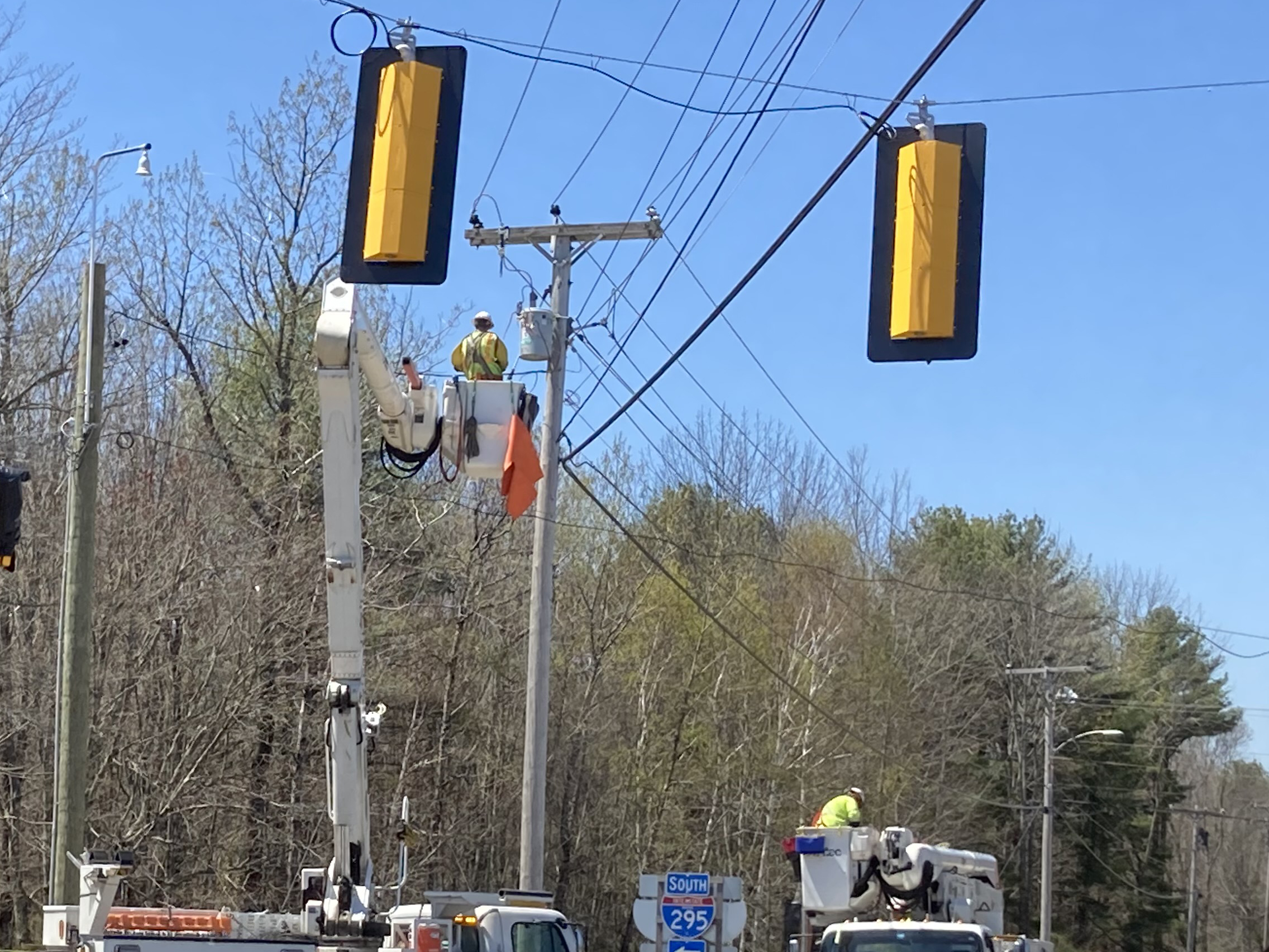 Wokers using cherry picker truck to access transformer